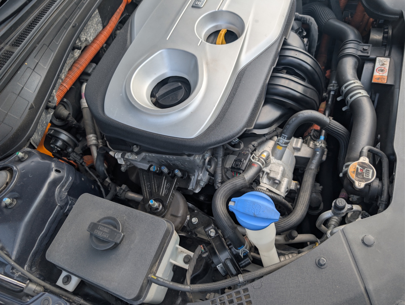 Komora silnika Kia Optima PHEV - widoczne pomarańczowe przewody wysokiego napięcia